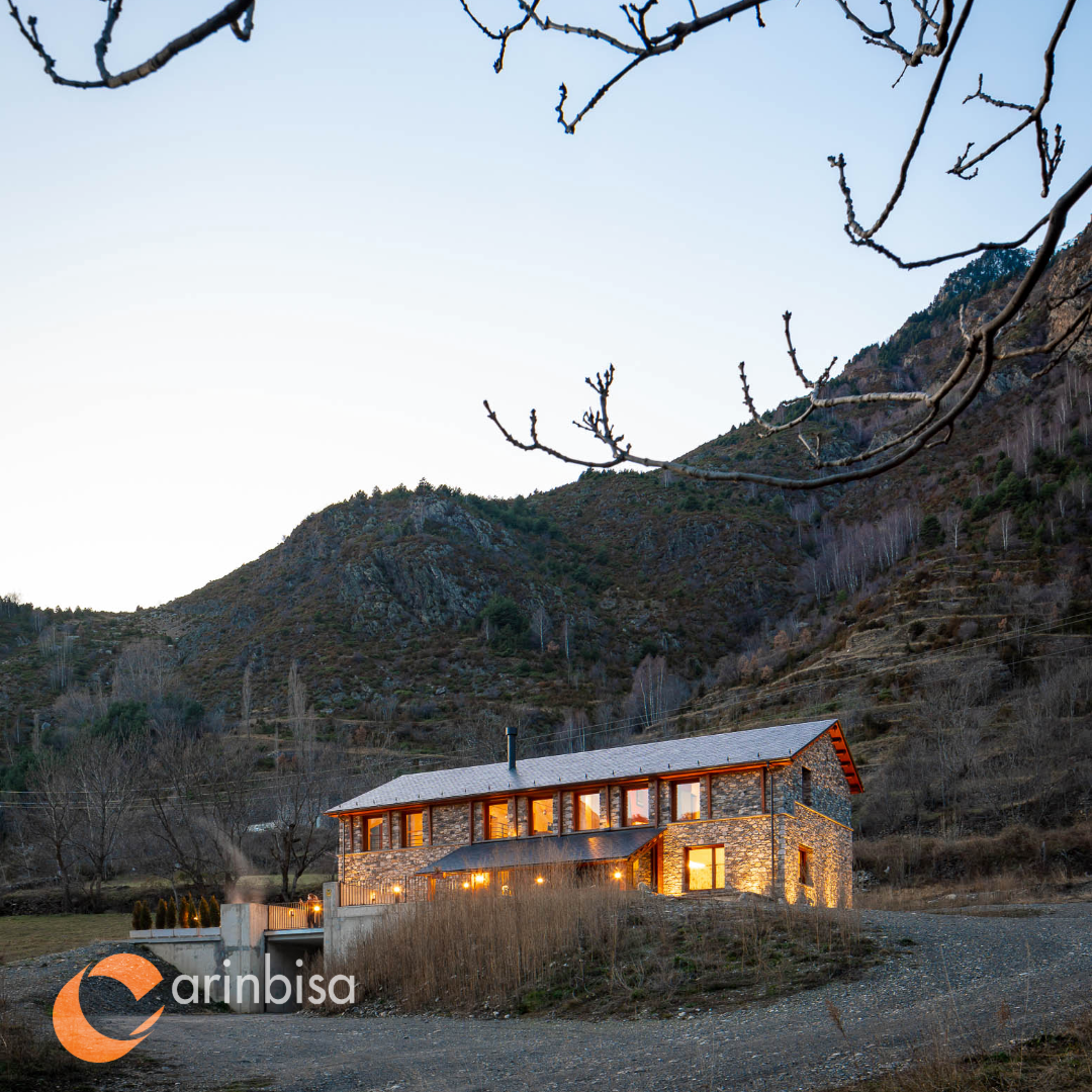 Casa Monago al atardecer, integrada en el paisaje de montaña