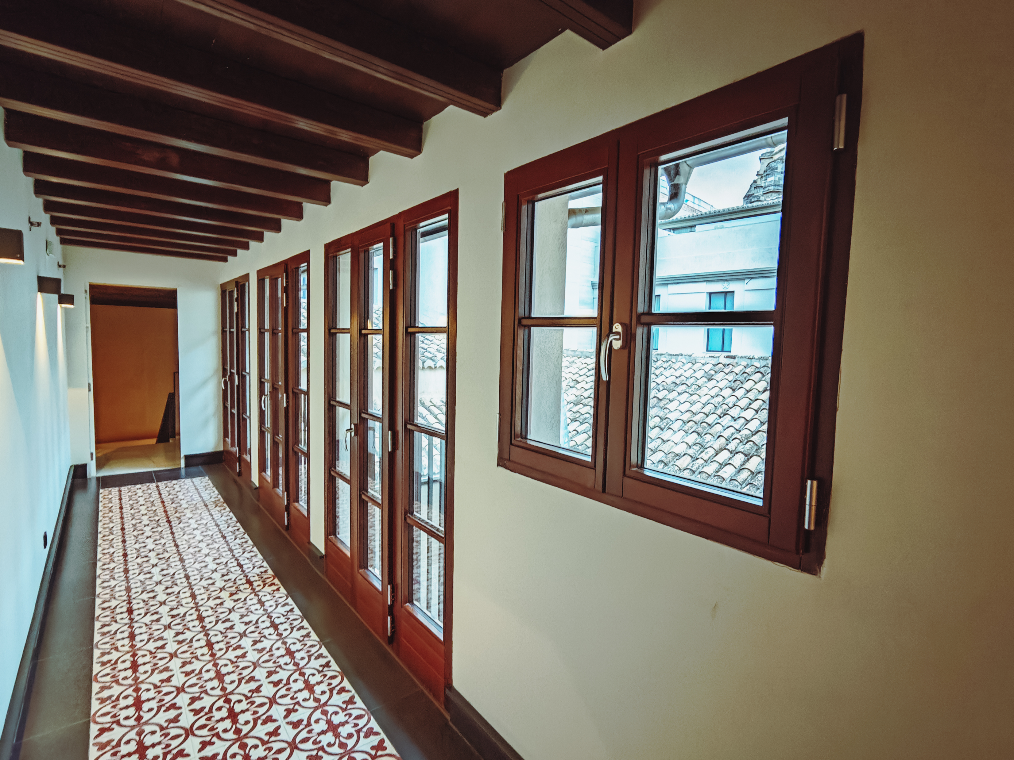 Galería interior con ventanas y puertas de madera en el Hotel Áurea Catedral