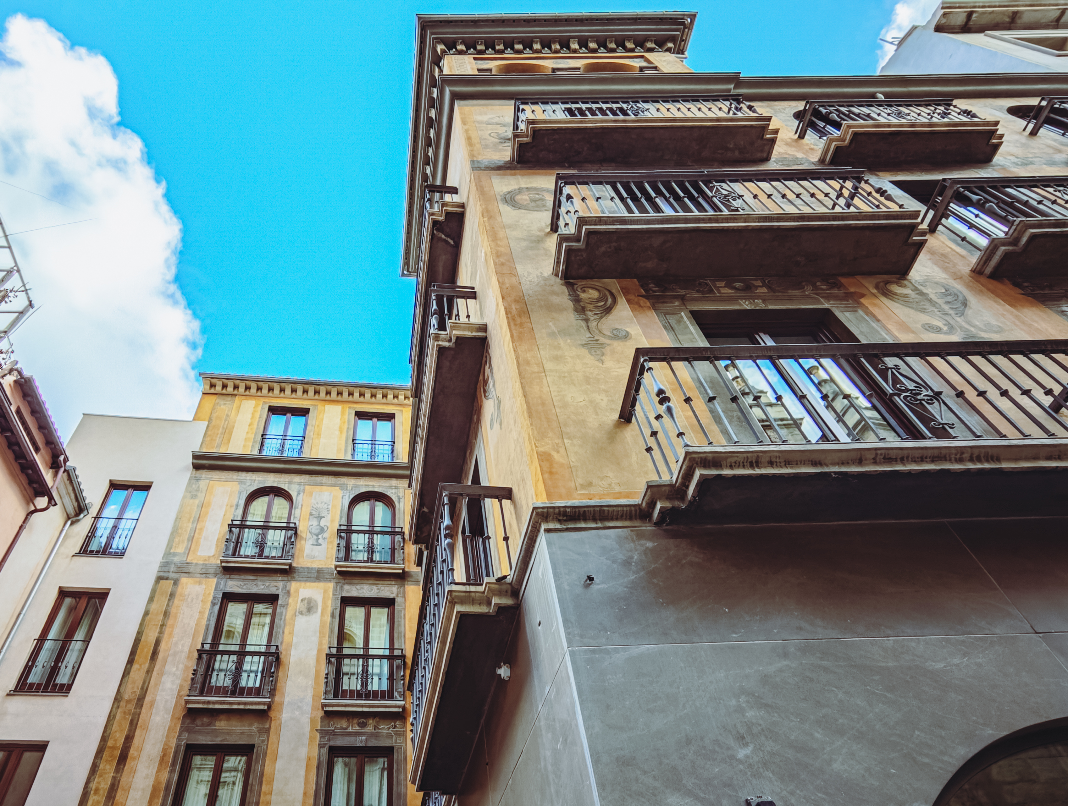Vista ascendente de la fachada histórica y sus balcones de madera