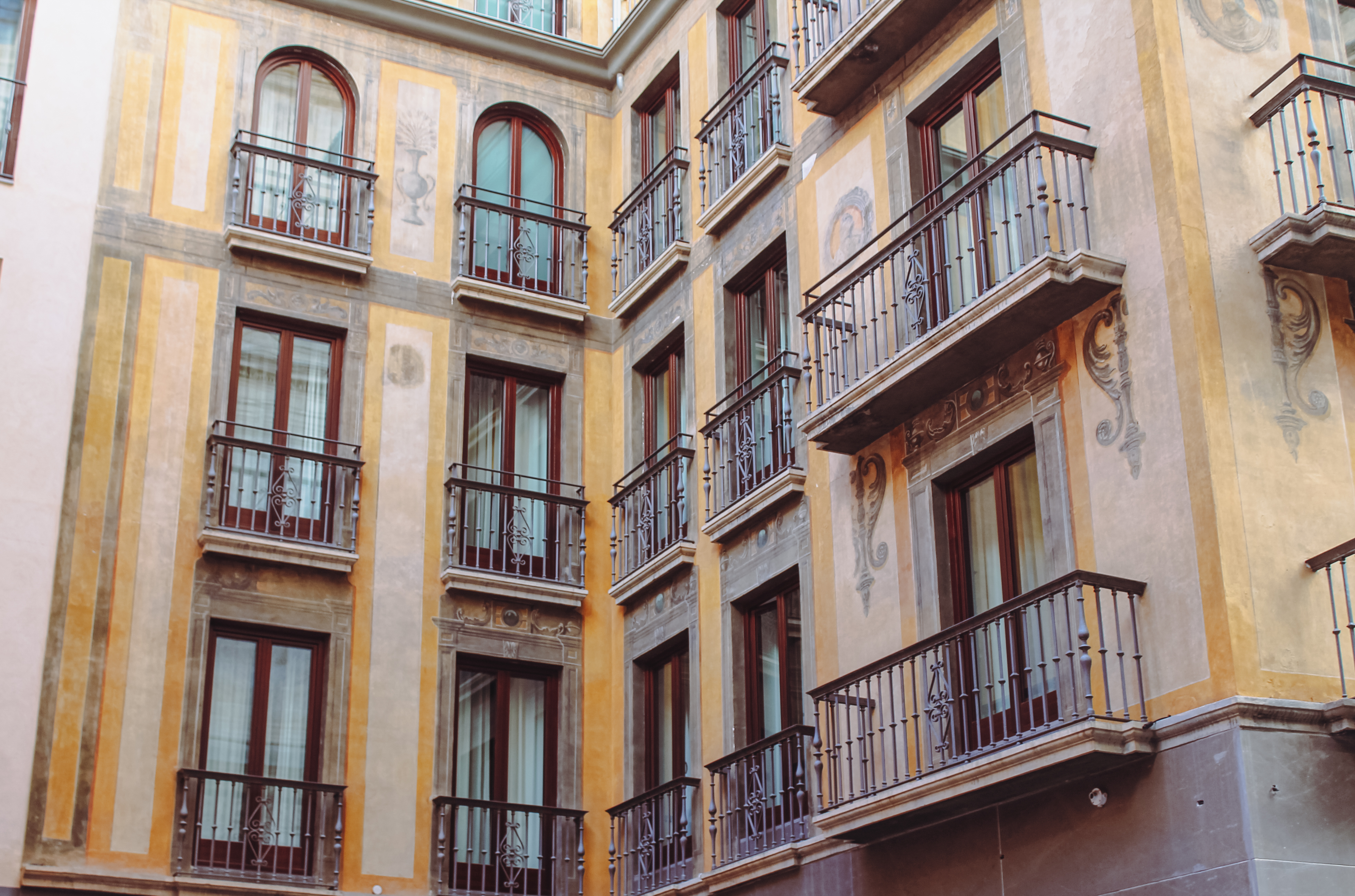 Ventanas de madera y balcones de forja integrados en la fachada rehabilitada