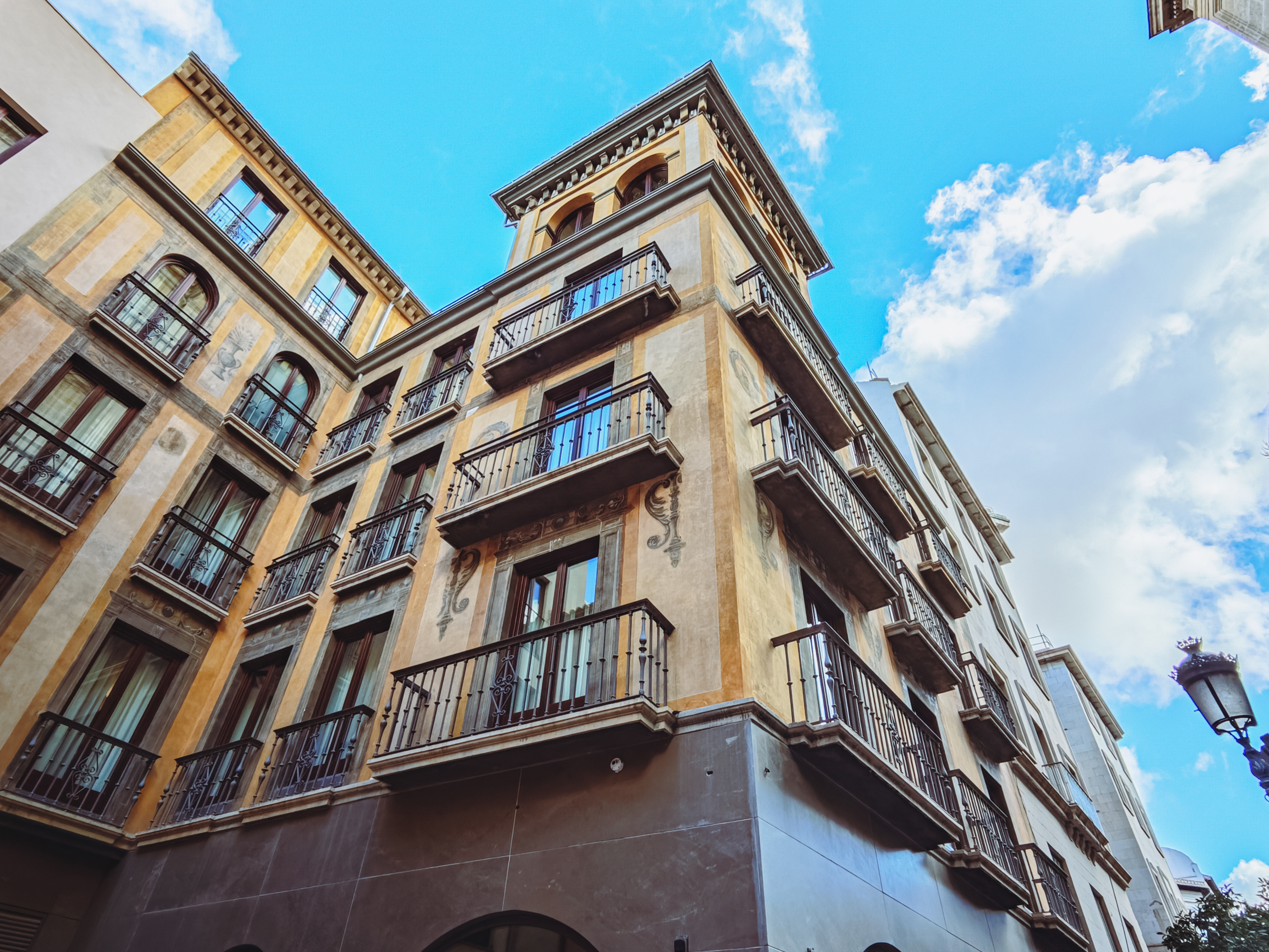 Fachada histórica del Hotel Áurea Catedral de Granada con ventanas y balcones de madera