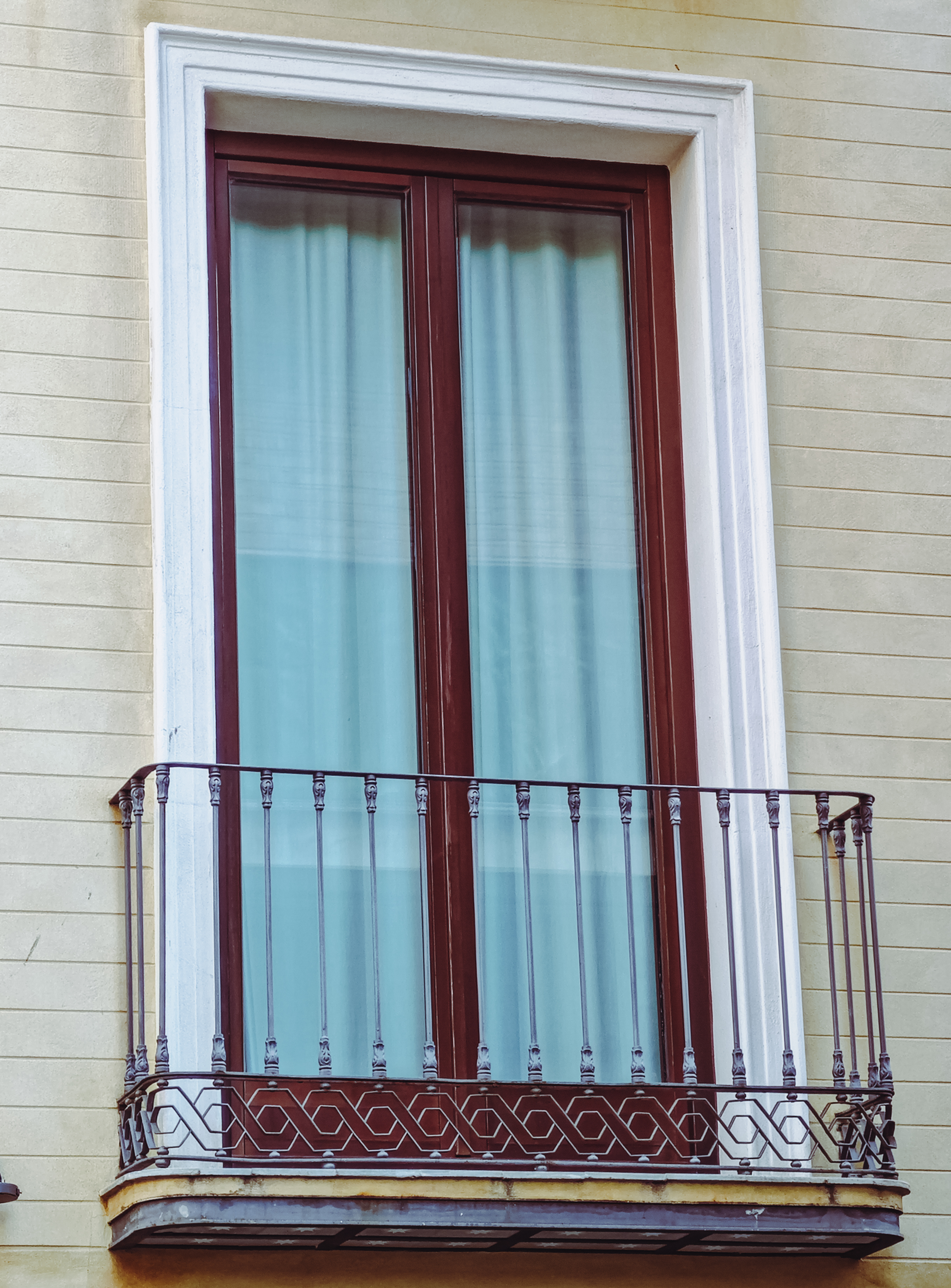 Detalle de una balconera de madera con barandilla metálica
