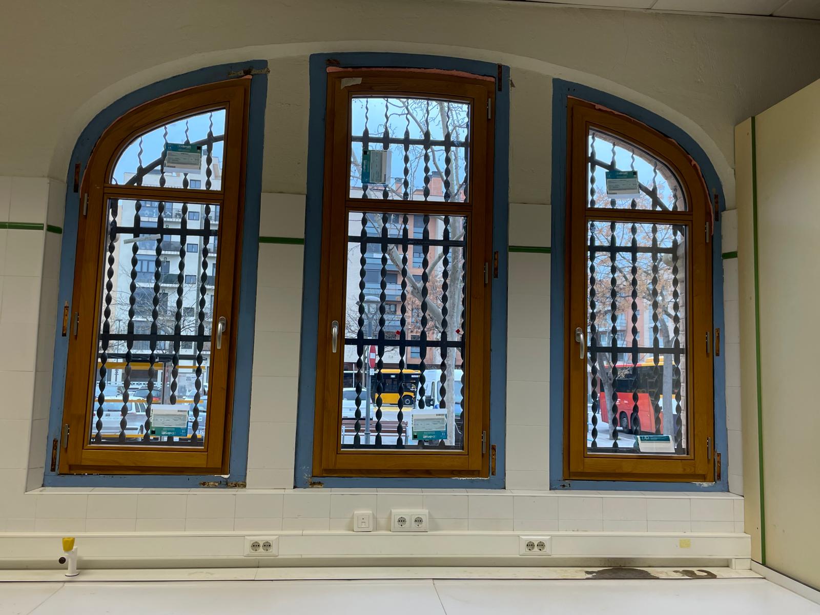 Tres ventanas interiores de madera con remates curvos en la Estación Enológica