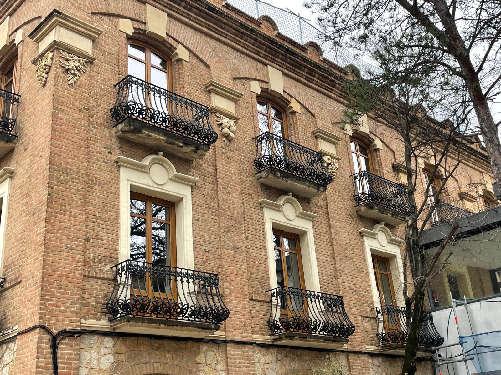 Detalle de ventanas de madera en la fachada de ladrillo de la Estación Enológica