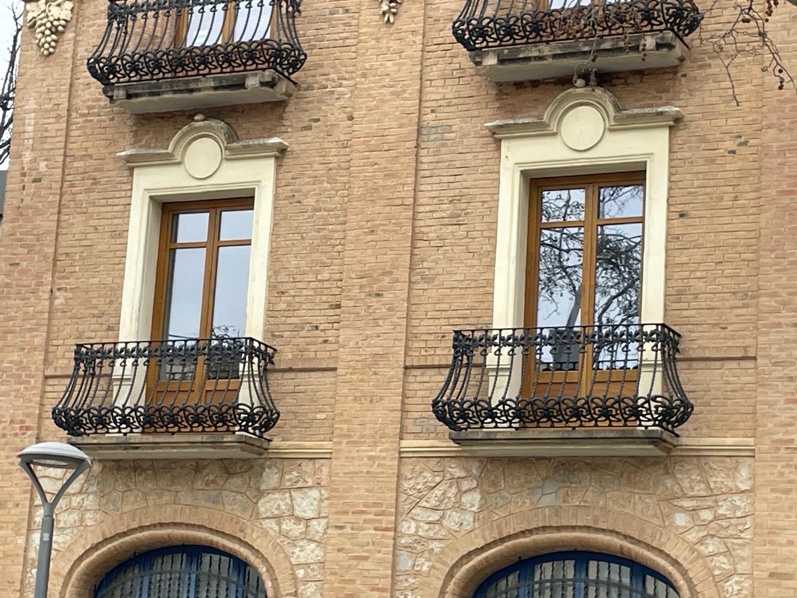 Detalle de ventanas de madera y balcones de forja en la fachada histórica